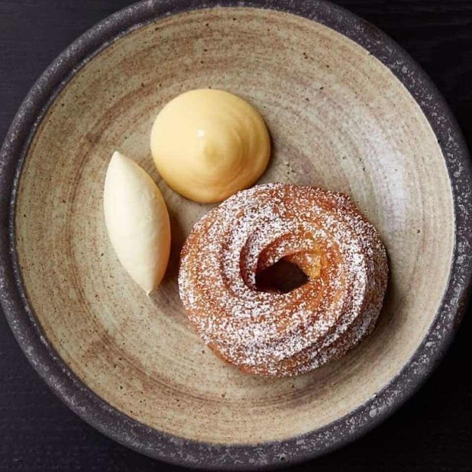 a doughnut sitting next to a cup of coffee